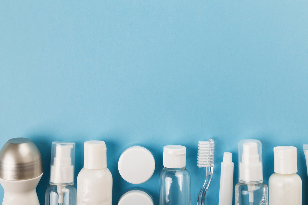 The contents of a bulk hygiene kit, including a toothbrush and various bottles, set against a light blue background.